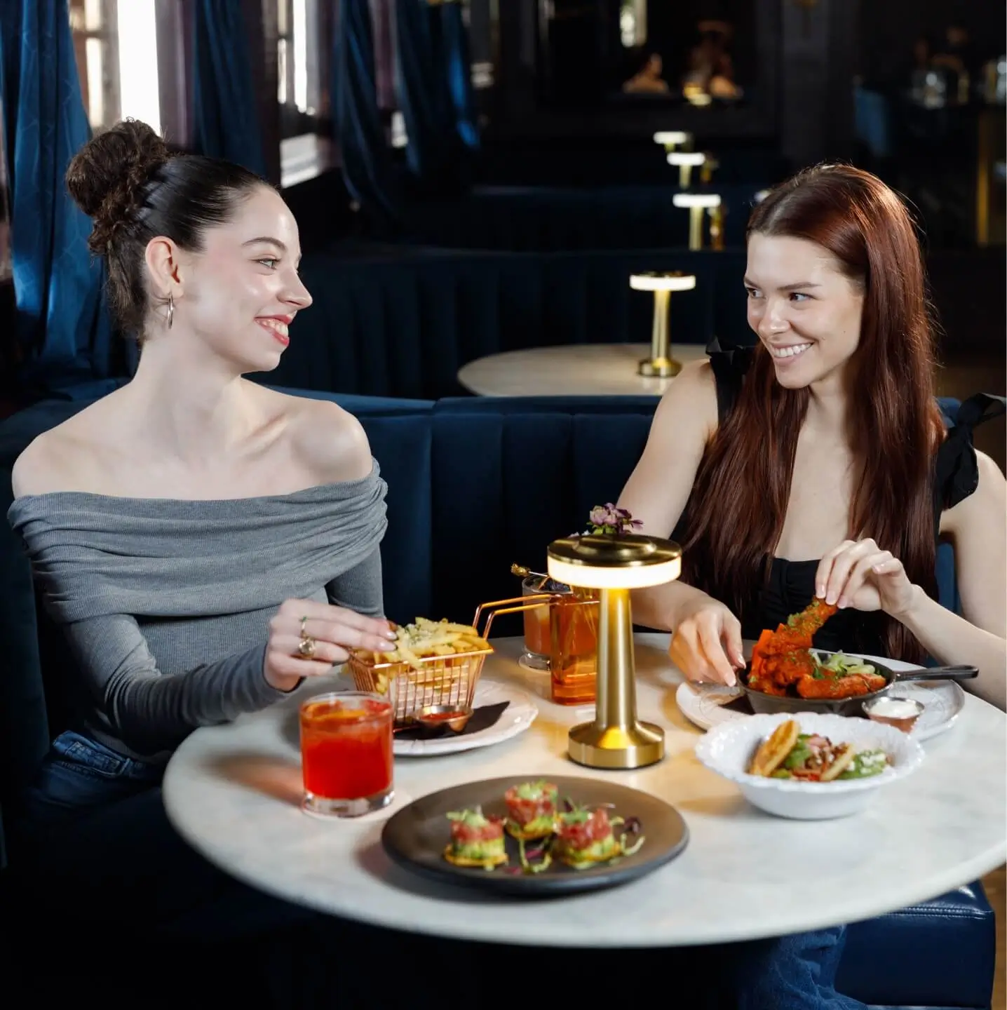 Two women sitting eating food